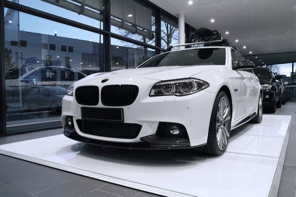 Factory Recommended Maintenance for European vehicles in Denver, CO with AutoImports of Denver. Image of white BMW in dealership window.