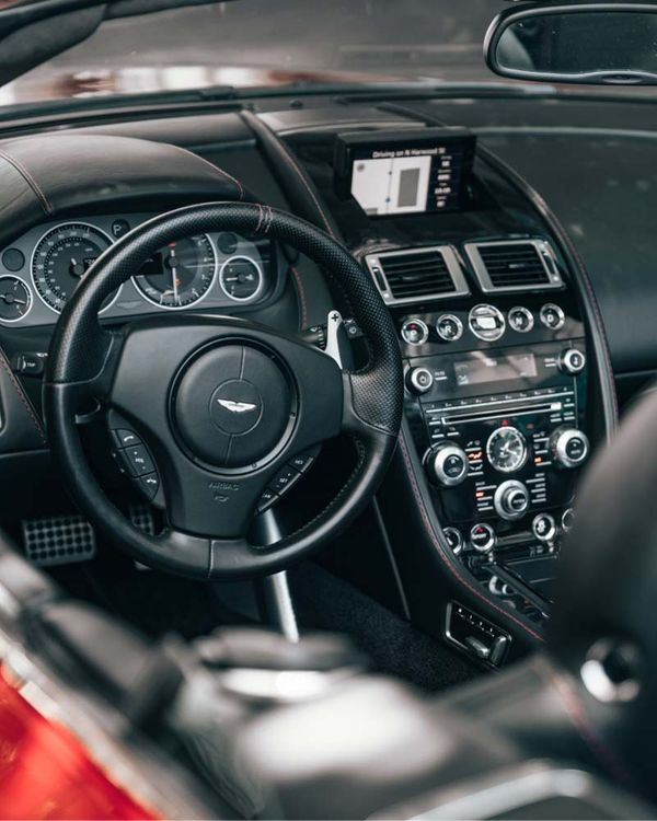 Aston Martin repair in Denver, CO. with AutoImports of Denver. Image of steering wheel and car dash from drivers side in an Aston Martin car.