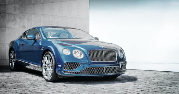 Bentley repair in Denver, CO. with AutoImports of Denver. Image of blue Bentley vehicle parked inn front of a cement wall.