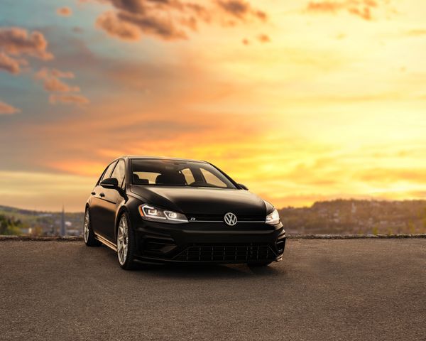 VW repair and Volkswagen repair in Denver, CO with Auto Imports of Denver. Image of black hatch back vw car parked with sunset sky in background.