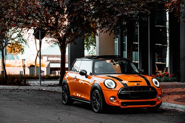 Mini Cooper Repair in Denver, CO with AutoImports of Denver. Image of orange and black mini cooper parked on the side of a residential road.