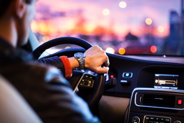 Steering System Repair in Denver, CO. at AutoImports of Denver. Image of man driving luxury car in the city at night. power steering