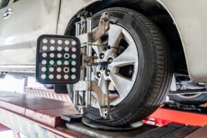 Wheel Alignment Service by AutoImports of Denver in Englewood, CO: Close-up of a car wheel on an alignment machine, highlighting the importance of precise wheel alignment and balancing for optimal vehicle performance and safety.